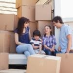 Family sitting on back of moving van