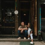 Właściciele małej kawiarni siedzący przed lokalem w przyjaznej atmosferze