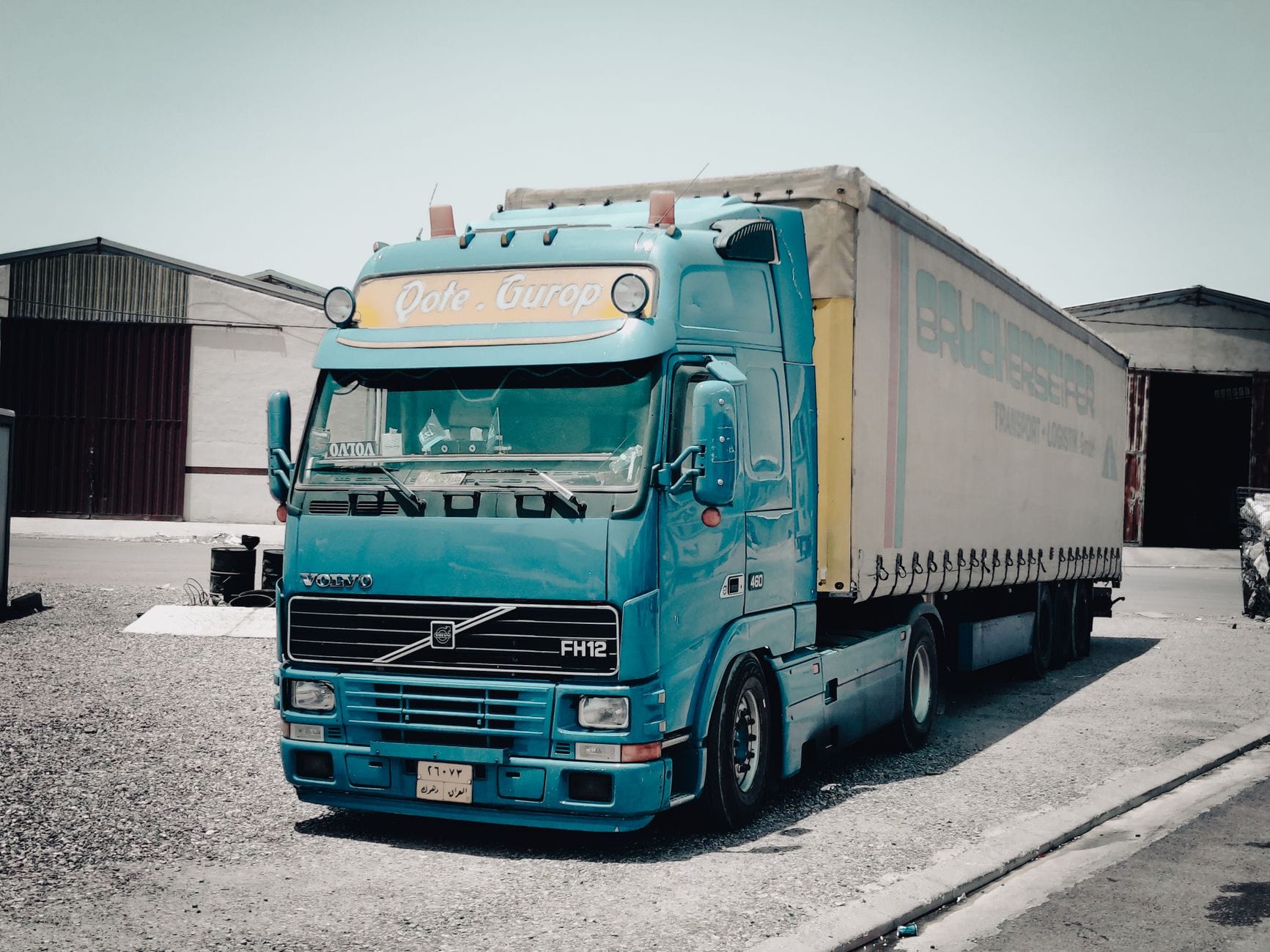 Niebieska ciężarówka Volvo zaparkowana przy magazynie w strefie przemysłowej